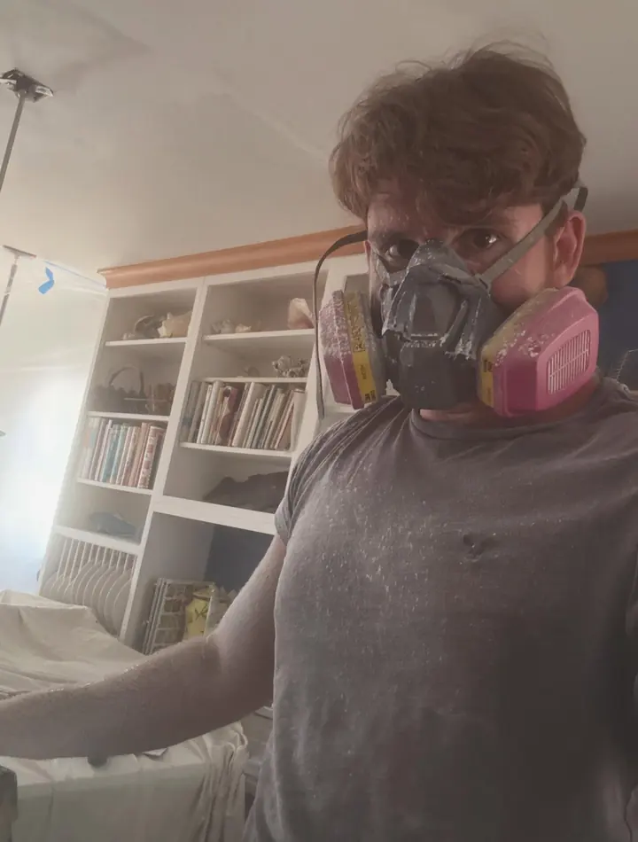Owen in a respirator mask, mid-job inside a client's home