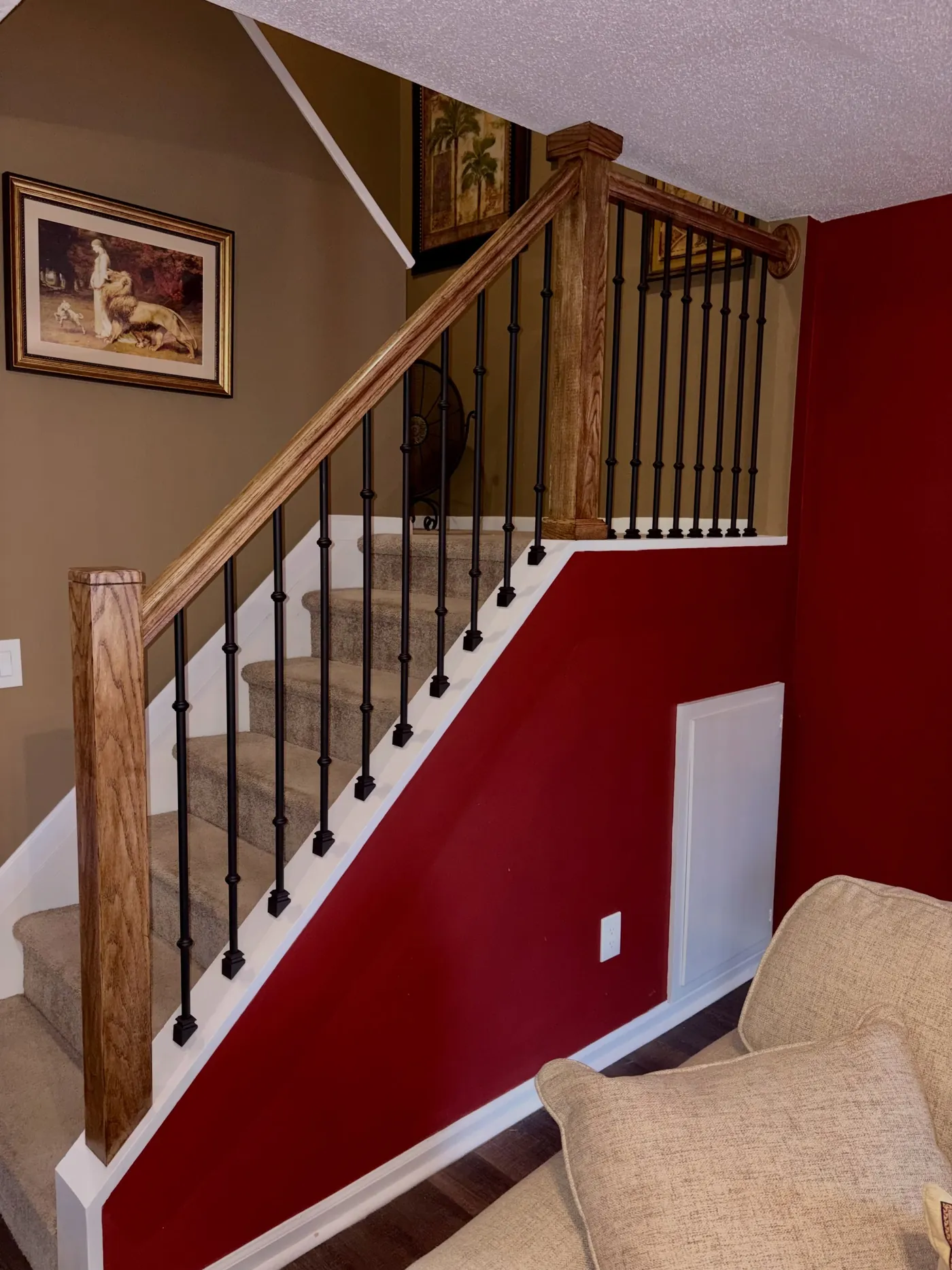 After: red oak handrail and newel post with black iron balusters